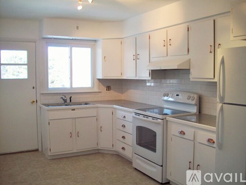 A kitchen with white cabinets and appliances.