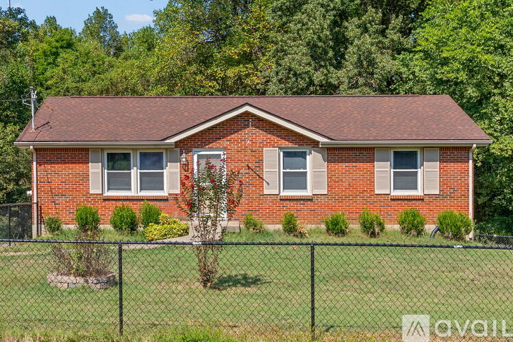 A red brick house with a black fence in front.