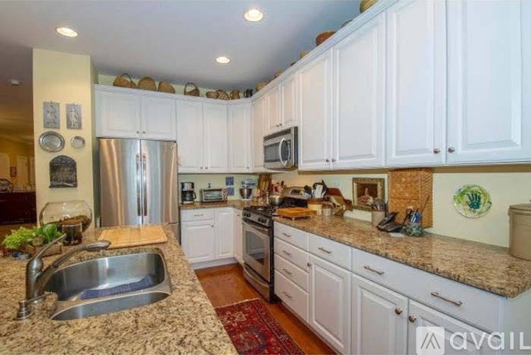 A kitchen with white cabinets and granite countertops.
