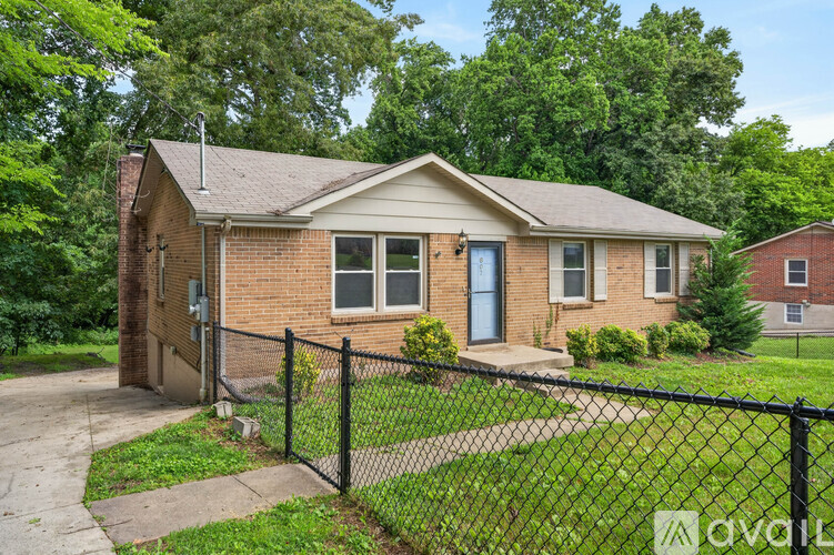 A house with a black fence in front of it is for sale.