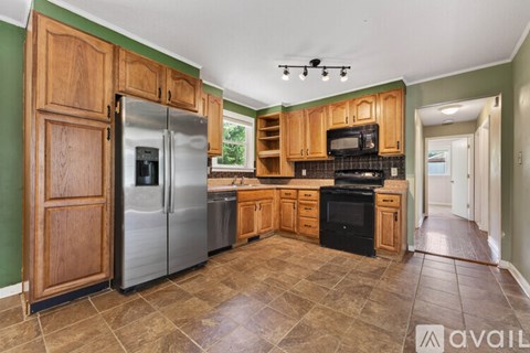 A kitchen with wooden cabinets and a tiled floor.