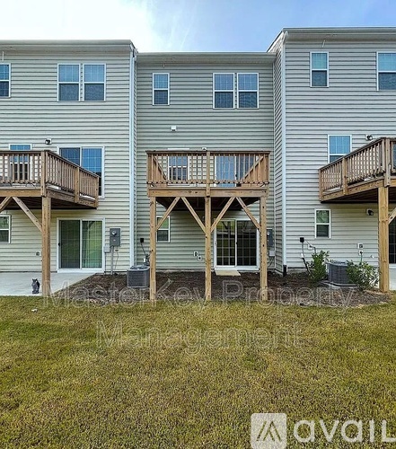 A row of houses with balconies and a grassy area in front.