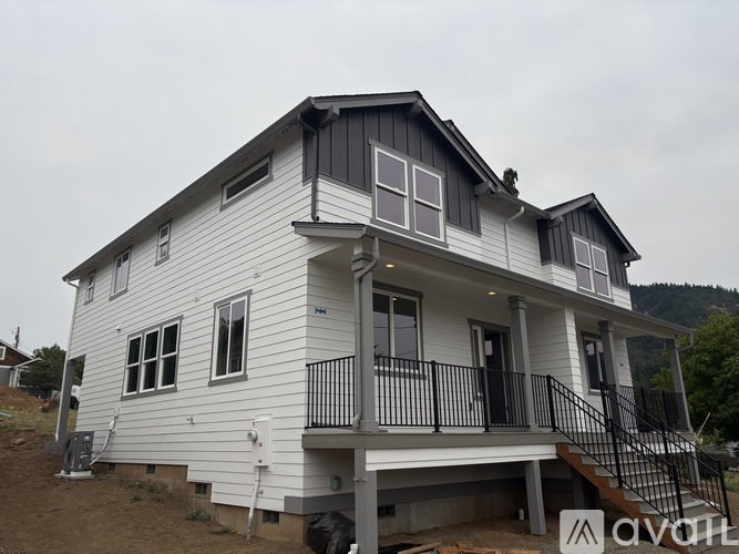A two-story house with a balcony and a staircase leading to the upper level.