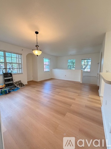 A room with wooden flooring and a pendant light hanging from the ceiling.