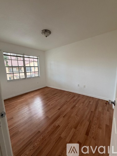 A room with wooden flooring and a window.