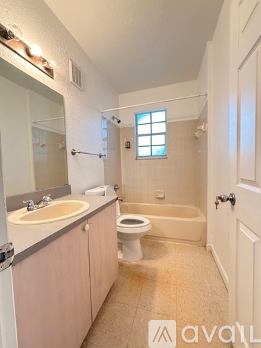 A bathroom with a sink, toilet, and bathtub.