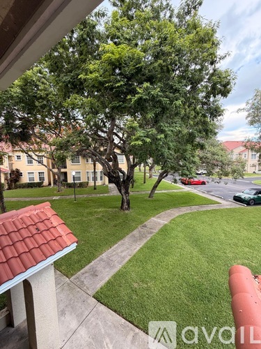 A tree in a yard with a building in the background.