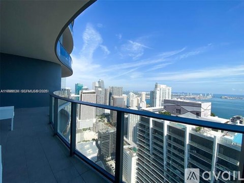 A balcony overlooks a cityscape with buildings and a body of water.