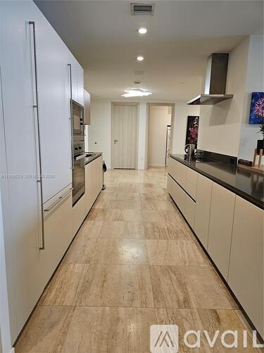 A kitchen with white cabinets and a wooden floor.