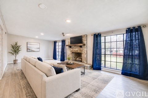 A living room with a beige couch and a fireplace.