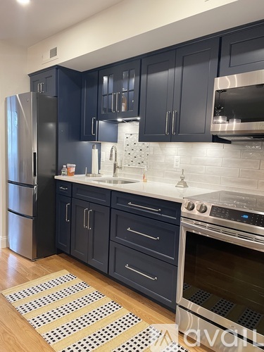 A kitchen with dark cabinets and a stainless steel refrigerator.