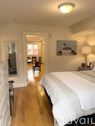 A bedroom with a large bed and a painting on the wall.