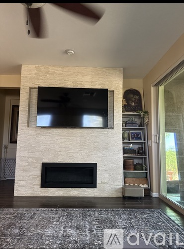 A modern living room with a flat screen TV mounted above a fireplace.