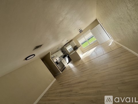 A modern interior with wooden floors and a kitchen area.