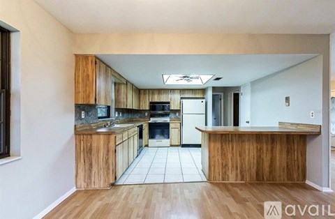 A kitchen with wooden cabinets and a white refrigerator.