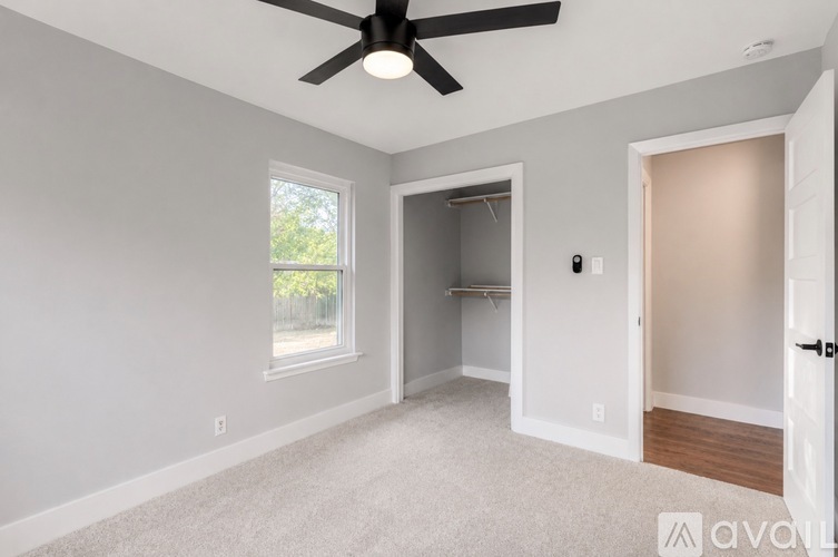 A room with a ceiling fan and a window.