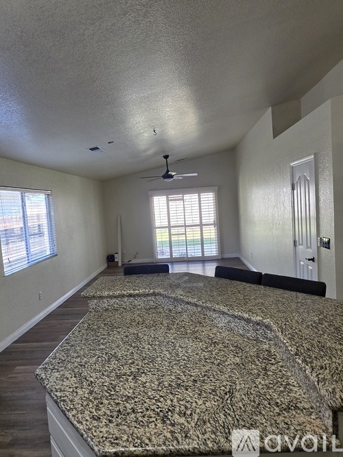 A bedroom with a large bed and a ceiling fan.