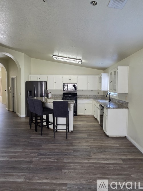 A kitchen with a table and chairs in the middle of the room.