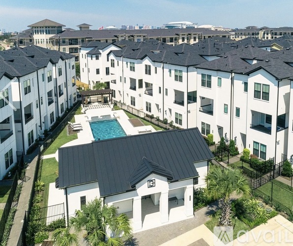 A large white building with a black roof and a pool in the middle of a courtyard.