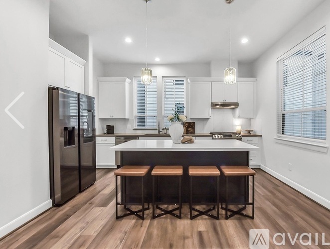 A modern kitchen with a center island and stools.
