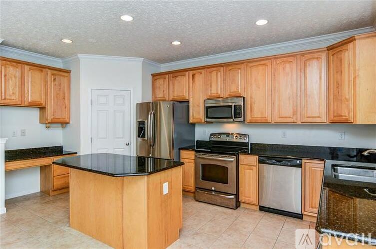A kitchen with wooden cabinets and black countertops.