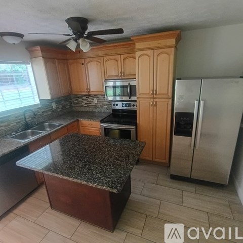 A kitchen with wooden cabinets and granite countertops.