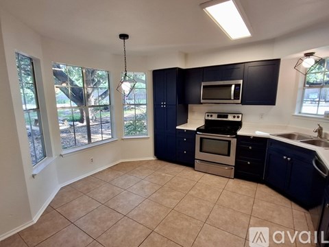 A kitchen with blue cabinets and a tiled floor.