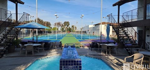 A pool with a slide and a table with chairs.