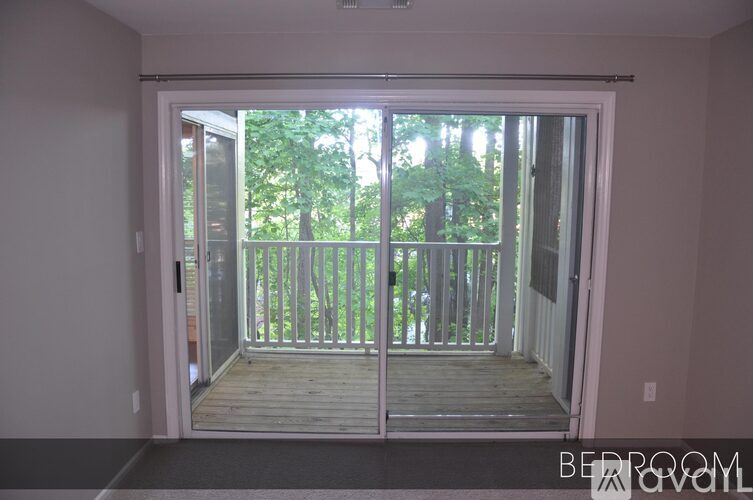 A bedroom with a sliding glass door leading to a deck.