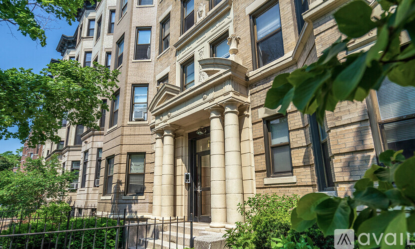 A large, beige building with a black fence in front.