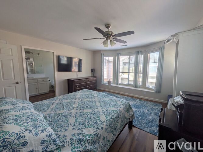 A bedroom with two beds and a ceiling fan.