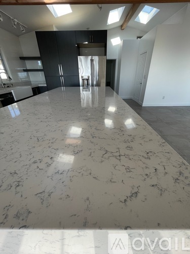 A spacious room with marble flooring and skylights.