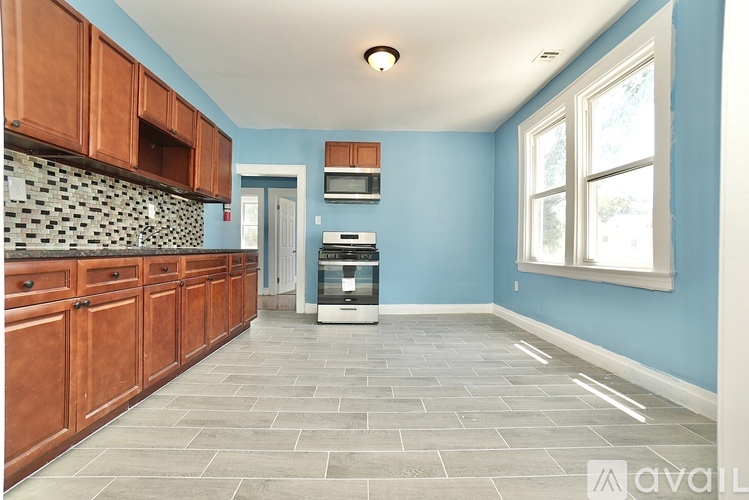 A kitchen with wooden cabinets and a blue wall.
