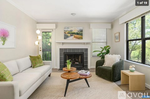 A living room with a fireplace and a painting on the wall.