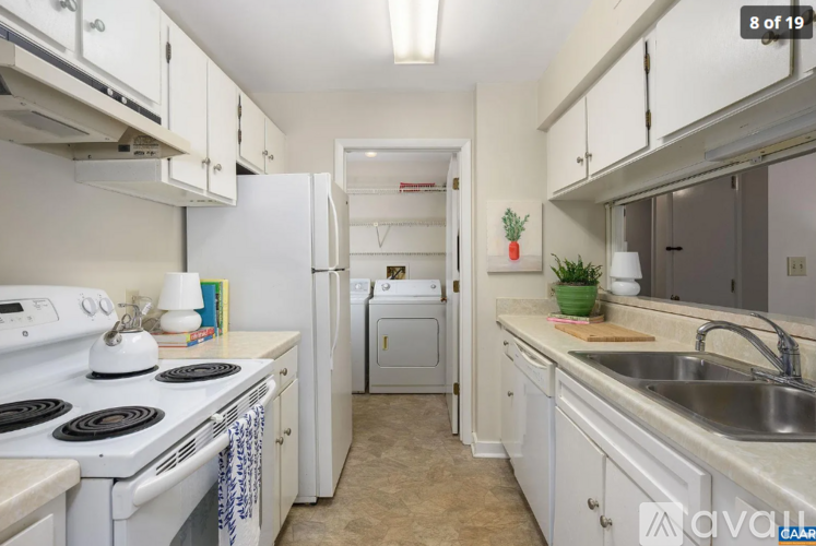 A kitchen with white appliances and cabinets.