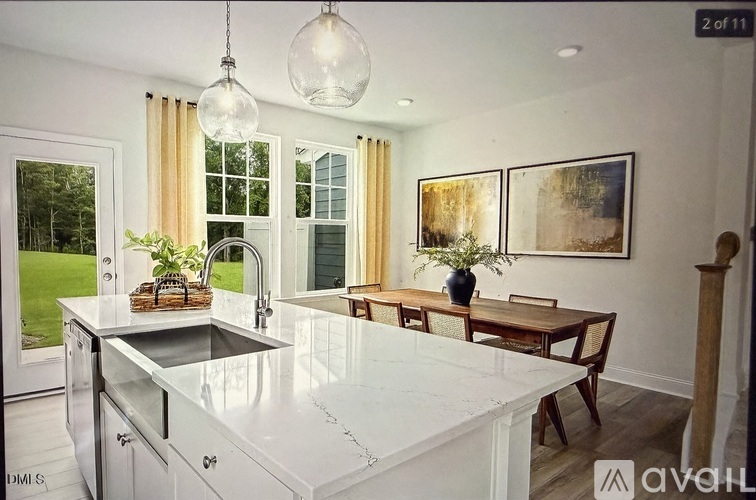 A kitchen with a white countertop and a dining table with chairs.