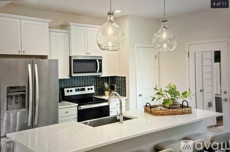A kitchen with a white countertop and a stainless steel refrigerator.