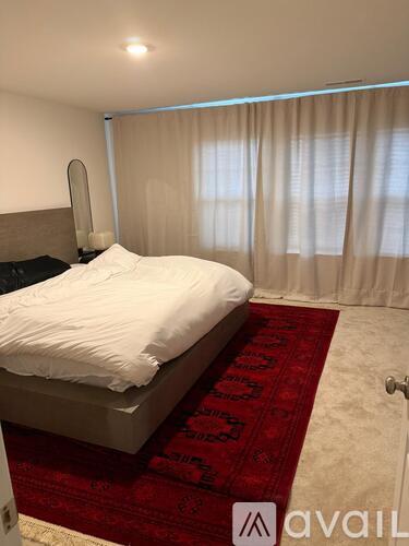 A bedroom with a large bed and a red carpet.