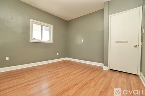 A room with wooden flooring and a white door.