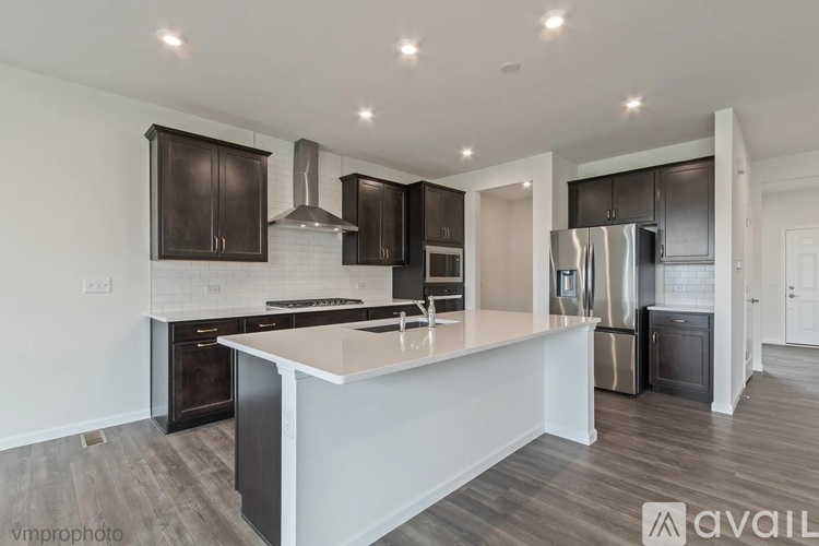 A modern kitchen with dark brown cabinets and stainless steel appliances.