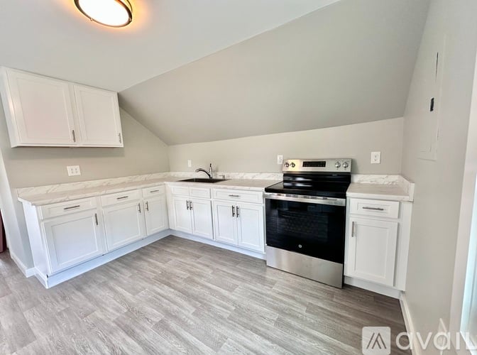 A kitchen with white cabinets and a black oven.