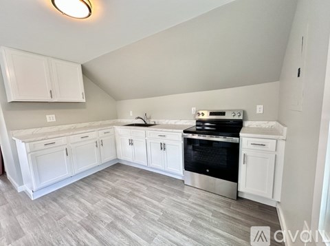 A kitchen with white cabinets and a black oven.