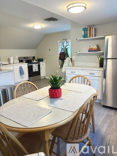 A dining room with a table set for two and a pineapple on the table.