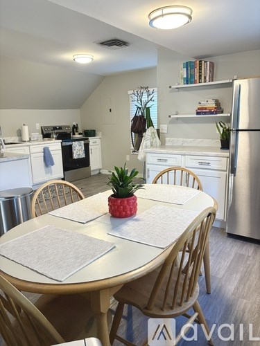 A dining room with a table set for two and a pineapple on the table.