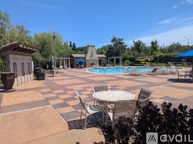A pool area with a table and chairs.