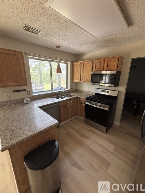 A kitchen with wooden cabinets and a granite countertop.
