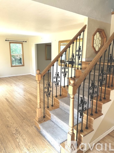 A staircase with wooden steps and black metal railings.