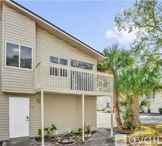 A beige house with a balcony and a door.