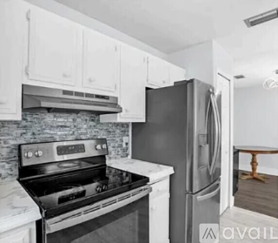 A kitchen with a black refrigerator and stove.