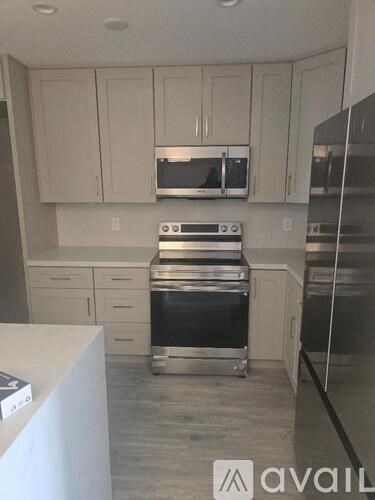 A kitchen with white cabinets and stainless steel appliances.